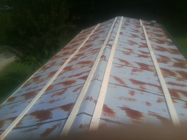 Rusted metal roof panels with new wood purlins before replacement — Storm Damage Roof Repair in Oliver Springs by Roofing Brothers