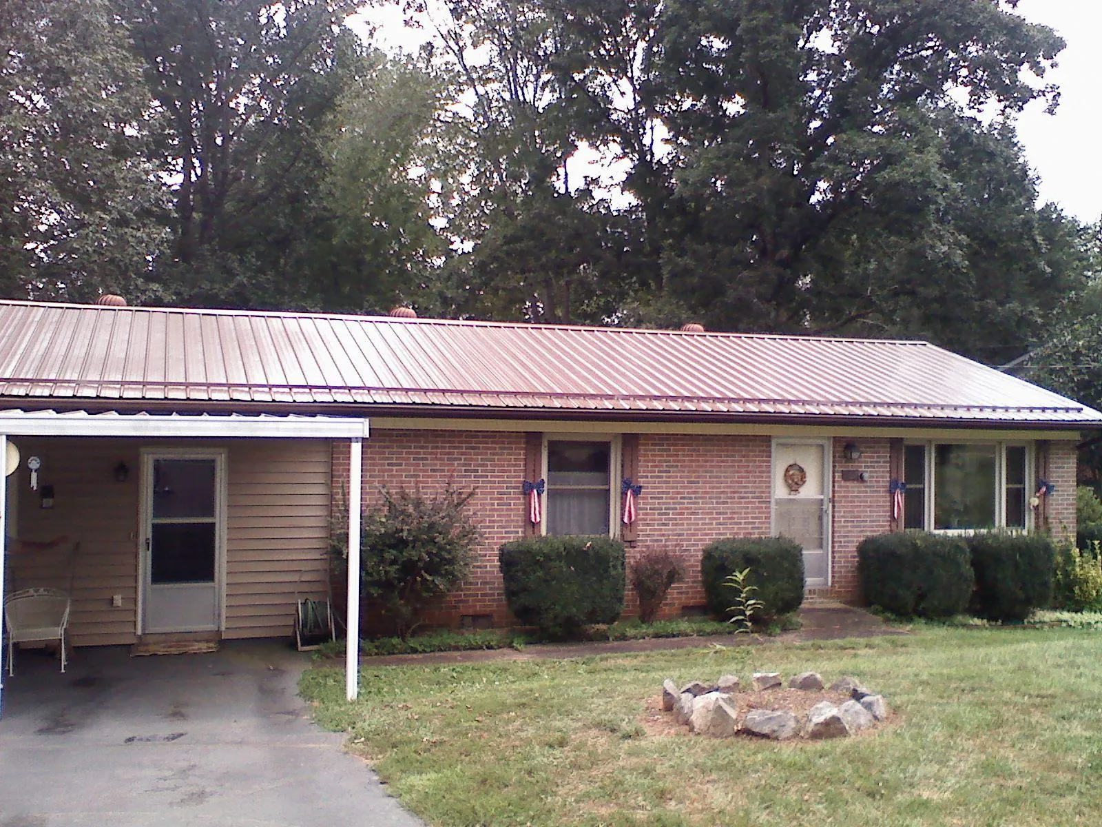 Bronze metal roof and carport on a brick ranch home — Roof Repair work by our crew in Oliver Springs